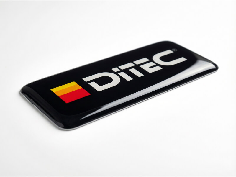 3D dome-klistermärke fotograferad i vinkel som visar kupolformad epoxyyta och tjocklek