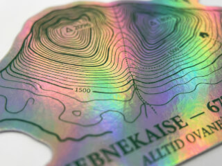 Stansad klistermärke i hologram med regnbågsskimrande yta på vit bakgrund