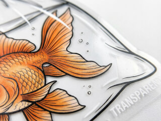 Transparent klistermärke med guldfisk-illustration mot vit bakgrund