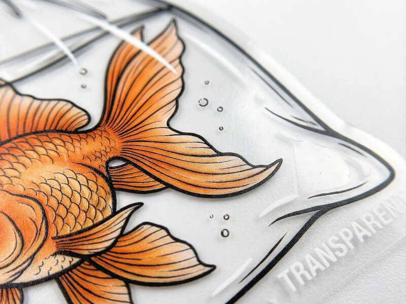 Närbild på transparent klistermärke som visar tryckkvalitet och genomskinlig kant