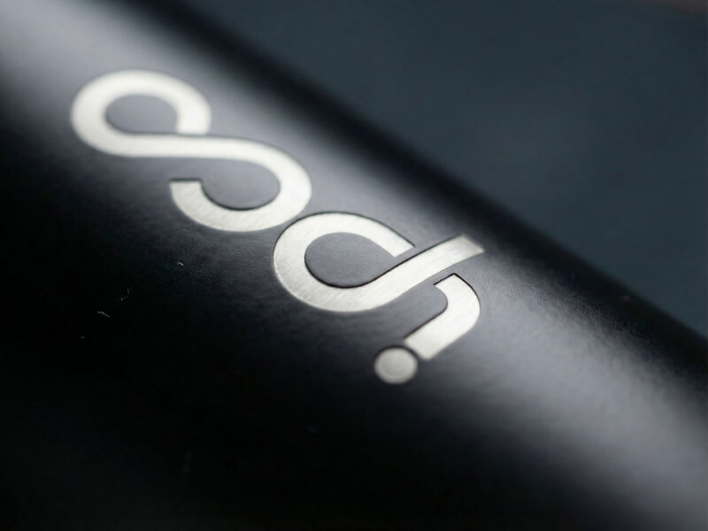 Närbild på en matt svart termosmugg Elwood med en precisionsgjord lasergraverad logotyp i silver.