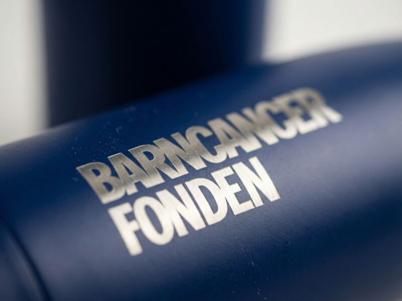 Närbild på en matt mörkblå Termosflaska Vasa med detaljerad lasergraverad logotyp i rostfritt stål.