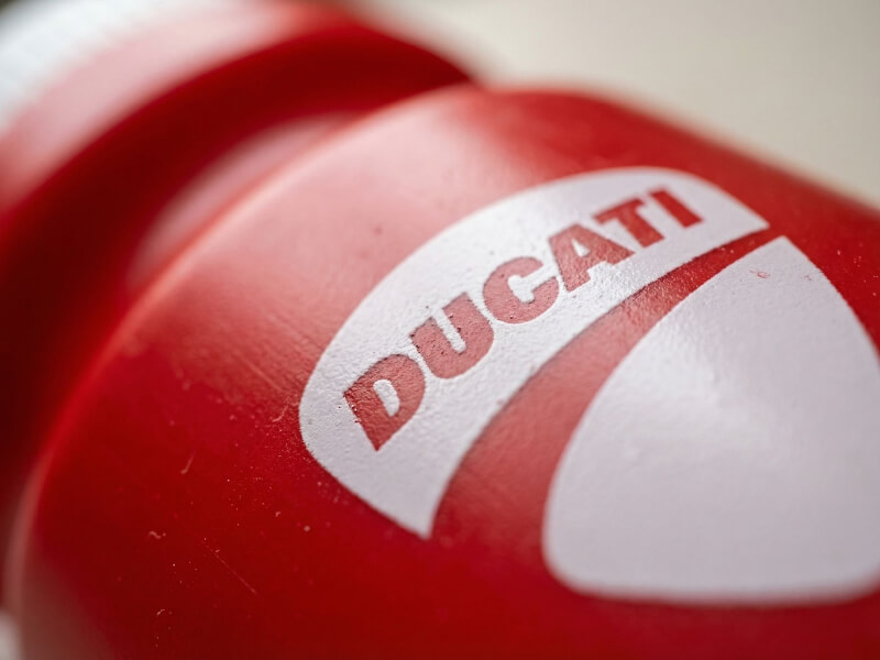 Närbild med mjuk fokusering av en vit Ducati-logotyp tryckt på en röd sportflaska