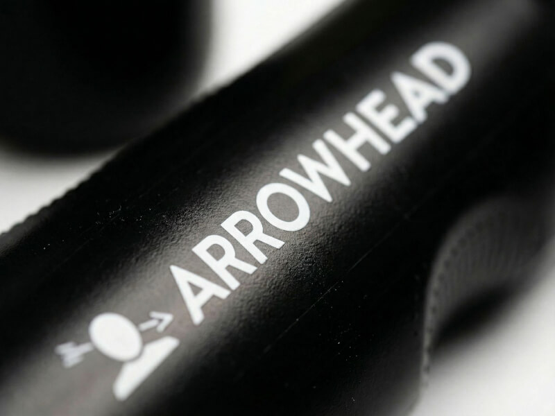 Närbild på vit Arrowhead Game Studios logotyp och text på en svart sportflaska