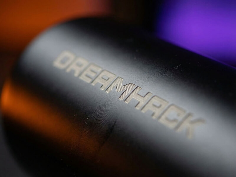 Närbild på grått och diskret Dreamhack-tryck på en matt svart sportvattenflaska upplyst av blått ljus