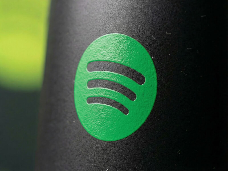 Närbild av en mattsvart Stengodsmugg Emma med en tryckt Spotify-logotyp i en stark grön färg.