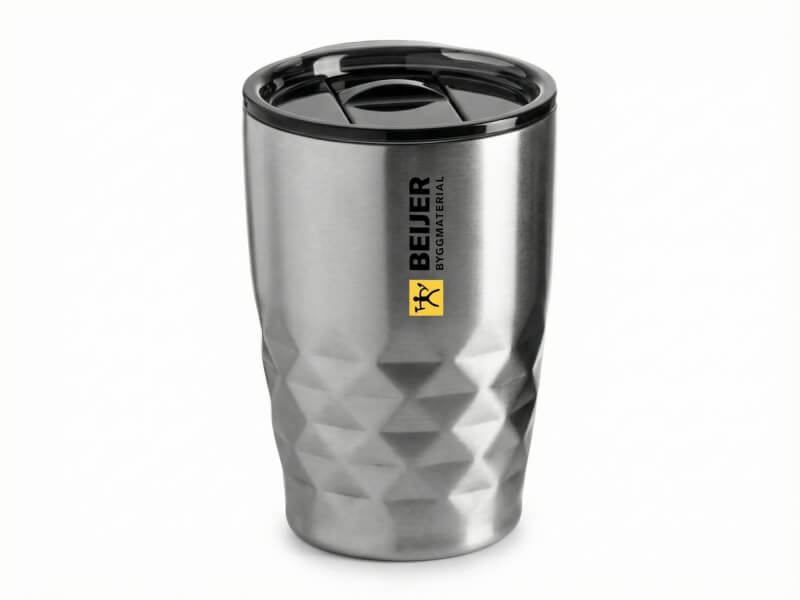 Termosmugg Geo i rostfritt stål med geometrisk yta, svart lock och Beijer Byggmaterial-logotyp tryckt på sidan.