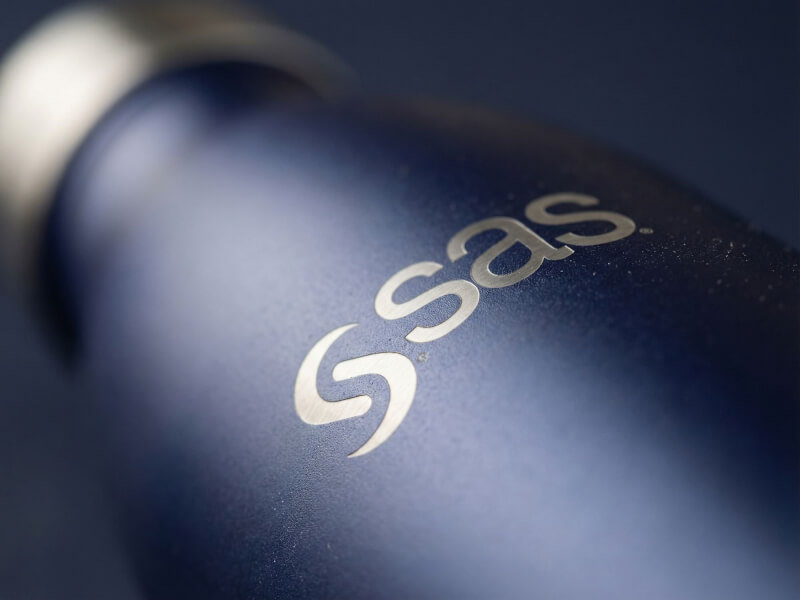 Detaljerad närbild av SAS-logotypen stilrent inbränd via gravyr som visar upp det underliggande silvriga oskyddade stålet