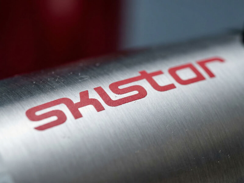 Närbild på termosmugg Miracle i borstat rostfritt stål med röd padtryckt SkiStar-logotyp.