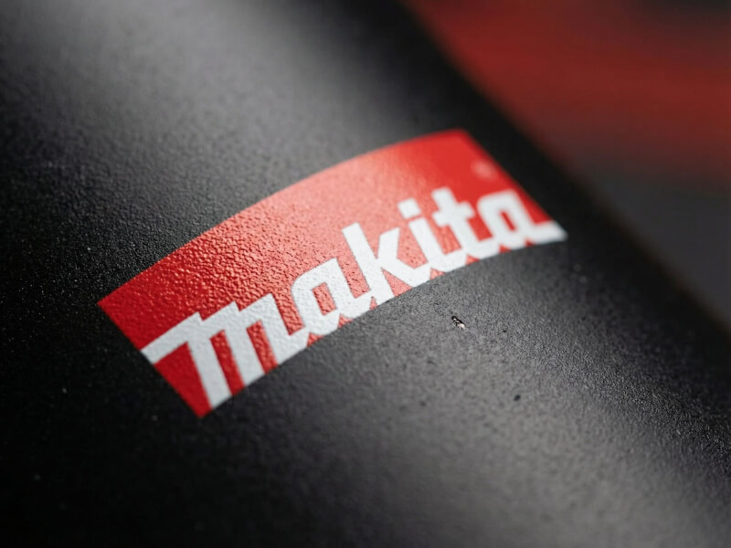 Närbild på en svart termosmugg Lagom med matt, texturerad yta och en tydligt tryckt Makita-logotyp i rött och vitt.