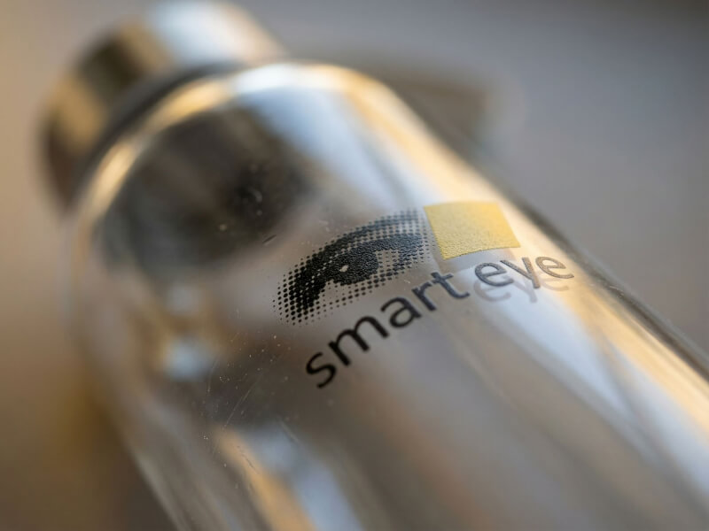Närbild av Smart Eye-logotyp tryckt på en elegant transparent vattenflaska