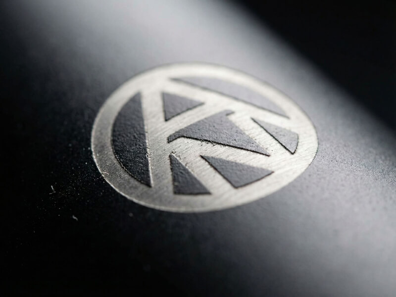 Högkvalitativ närbild av stålgrå, lasergraverad monnogramlogotyp för Arvid Nordquist på den svarta ytan av en termos