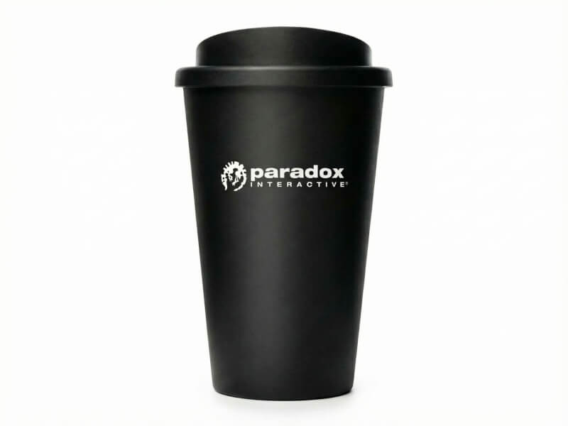 Svart matt Plastmugg Americano med Paradox Interactive-logotyp tryckt i vitt, isolerad mot vit bakgrund.