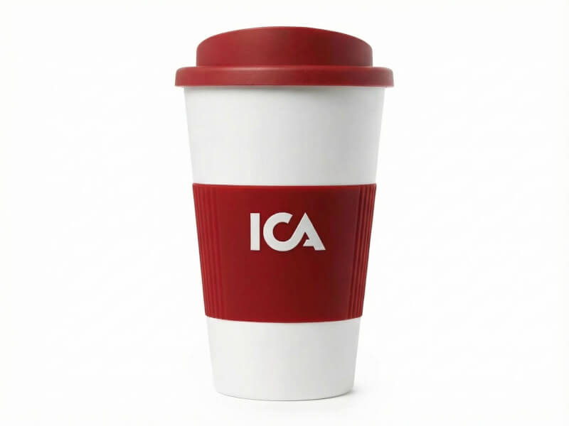 Plastmugg Americano Grip i vitt med rött lock och räfflat greppvänligt silikonband med tryckt ICA-logotyp, isolerad produktbild.