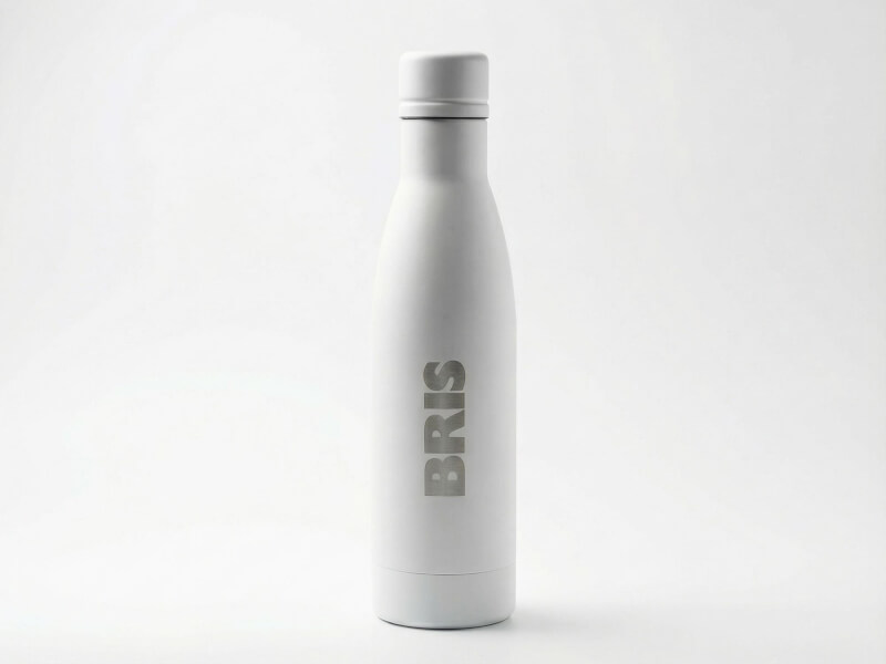 Matt vit Termosflaska Vasa Återvunnen med lasergraverad BRIS-logotyp i framhävt rostfritt stål, fotograferad mot en ren vit studiomiljö.
