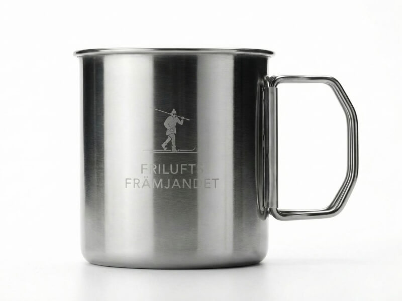 Kaffemugg Nunavut i rostfritt stål med borstad metallic-finish och lasergraverad logotyp för Friluftsfrämjandet, isolerad mot vit bakgrund.