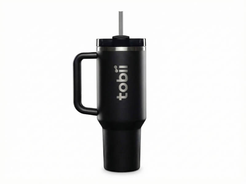 Svart matt termosmugg Quencher med handtag och lasergraverad Tobii-logotyp, stående mot vit bakgrund.