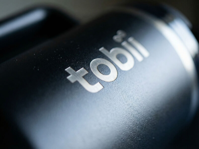 Närbild på en mattsvart termosmugg Quencher med Tobii-logotypen framhävd genom precisionslaser gravyr.